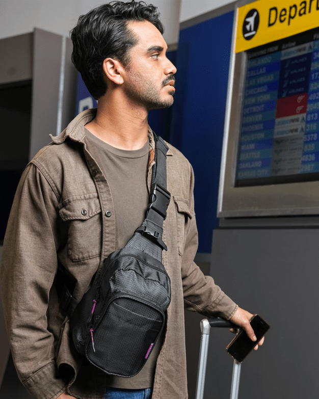 Man wearing On - The - Go Sling Pack in an airport